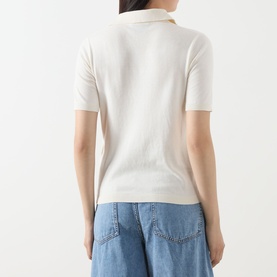 Model wearing Max Mara Weekend Roncolo Knit Polo Shirt in ecru, back view, ribbed short sleeves and collar, styled with light blue jeans.
