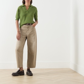 Model wearing Max Mara Weekend Albero Open Collar Knitted Polo Shirt in green, styled with beige wide-leg trousers and black chunky loafers.