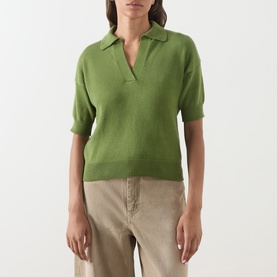 Model wearing Max Mara Weekend Albero Open Collar Knitted Polo Shirt in green with short sleeves and open placket, styled with beige trousers.