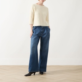 Model wearing Max Mara Weekend Addotto Knit Sweater in ecru with wide-leg blue jeans and black heeled mules.