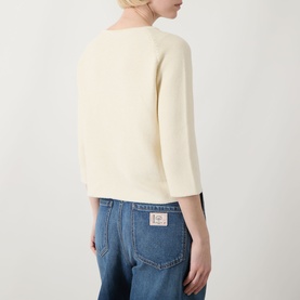 Model wearing Max Mara Weekend Addotto Knit Sweater in ecru, showing back view with three-quarter sleeves, styled with blue jeans.