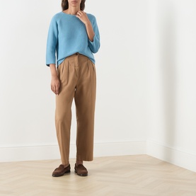 Model wearing Max Mara Weekend Addotto Knit Sweater in light blue with tan wide-leg trousers and brown loafers.