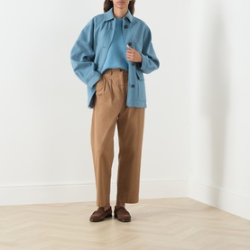 Model wearing Max Mara Weekend Addotto Knit Sweater in light blue, styled with a blue overshirt and tan wide-leg trousers, brown loafers.