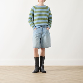 Model wearing Max Mara Weekend Ghiacci Stripe Sweater in green and blue stripes with denim shorts and black knee-high boots.
