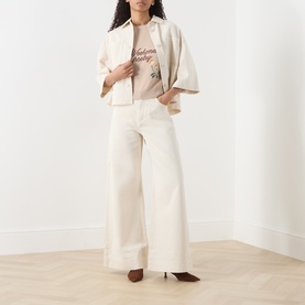 Model wearing Max Mara Weekend Sand Writing cotton knit top, styled with cream wide-leg trousers and a cropped ivory jacket.