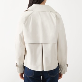 Model wearing Max Mara Weekend Boero Water-Repellent Jacket in Ivory Bicolour, showing rear view with back pleat detail, styled with blue jeans.