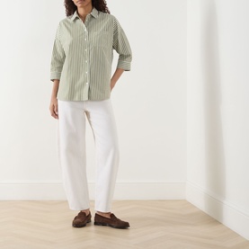 Model wearing Max Mara Weekend Giralda Striped Shirt in green fine stripe with white wide-leg trousers and brown loafers.