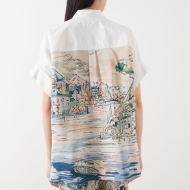 Model wearing Max Mara Weekend white cotton shirt, back view showing silk panel with scenic harbour illustration print, short sleeves