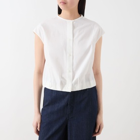 Model wearing Max Mara Weekend Gelatina Cropped Blouse in white, collarless with cap sleeves and front button fastening, styled with dark navy