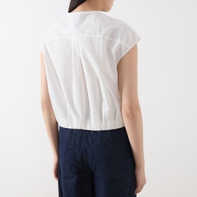 Model wearing Max Mara Weekend Gelatina Cropped Blouse in white, showing rear box pleat detail and elasticated hem, styled with navy wide-leg
