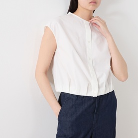 Model wearing Max Mara Weekend Gelatina Cropped Blouse in white, collarless with cap sleeves and front button fastening, styled with dark denim