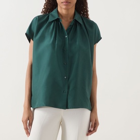 Model wearing Max Mara Weekend Crine Silk Shirt in dark green with collar, button front, short sleeves, styled with white trousers