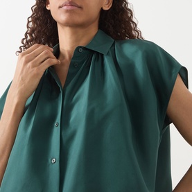Model wearing Max Mara Weekend Crine Silk Shirt in dark green with collared neckline, button fastening, and short sleeves