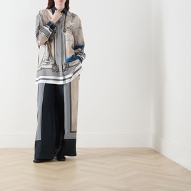 Model wearing Max Mara Main Teglia Printed Shirt in Stone Boats, 100% silk with boat-themed print, styled with wide-leg black trousers.