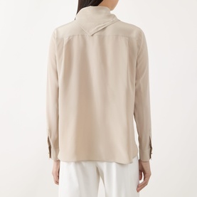 Model wearing Max Mara Dry Bow-Neck Silk Blouse in stone, rear view, with structured buttoned cuffs and straight hem, styled with white trousers.