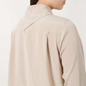 Model wearing Max Mara Main Dry Bow-Neck Silk Blouse in stone, back view showing relaxed silk drape and back yoke detail.