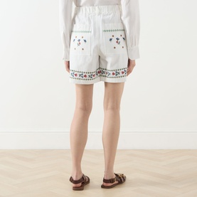 Model wearing Max Mara Weekend Obice Embroidered Shorts in White Cross, rear view showing floral embroidery, patch pockets and elasticated waist.