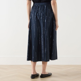 Model wearing Max Mara Weekend Fiordi Embellished Flared Skirt in navy, featuring vertical sequin stripes, midi length, and elasticated waist.