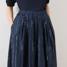 Model wearing Max Mara Weekend Fiordi Embellished Flared Skirt in navy with vertical sequin stripe detailing, midi length, paired with a black top.