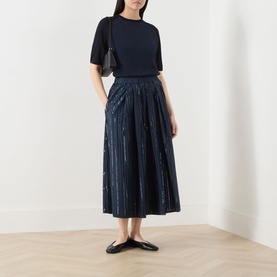 Model wearing Max Mara Weekend Fiordi Embellished Flared Skirt in navy with black short-sleeve top and black ballet flats