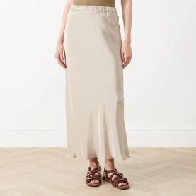 Model wearing Max Mara Main stone silk maxi skirt with elasticated waist, styled with brown strappy flat sandals.