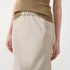 Model wearing Max Mara stone silk midi skirt with elasticated ruched waistband, styled with a khaki knit top.