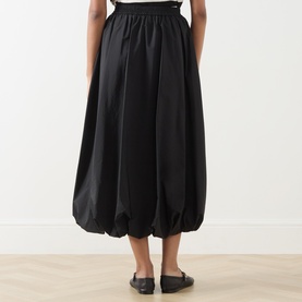 Model wearing Max Mara Weekend Ciurma Bubble Skirt in black, showing elasticated waistband, bubble hem, and midi length from the back.