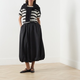Model wearing Max Mara Weekend Ciurma Bubble Skirt in black with white and black stripe top and black flat mules.