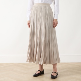 Model wearing Max Mara Weekend ivory pleated midi skirt with elasticated waist, styled with a white shirt and black mary jane flats.
