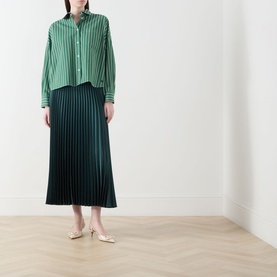 Model wearing Max Mara Weekend Nicchia Pleated Skirt in dark green, midi length with pleated structure, styled with a green striped shirt and cream