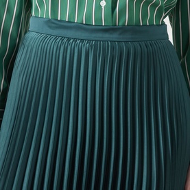 Model wearing Max Mara Weekend Nicchia Pleated Skirt in dark green, midi length with wide waistband, styled with a green striped shirt.