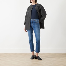 Model wearing Max Mara Weekend Multia Stretch Top in navy with grey oversized coat, blue cropped jeans and black loafers.