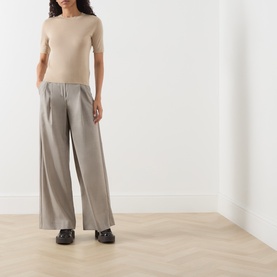 Model wearing Max Mara Weekend Tapioca Fine-Knit Sweater in sand with wide-leg grey trousers and black loafers