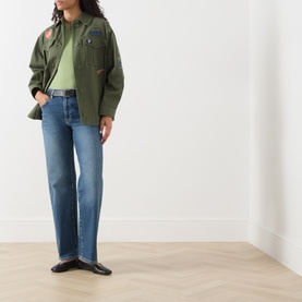 Model wearing Max Mara Weekend green wool-silk-cashmere T-shirt, styled with khaki military jacket and blue straight-leg jeans