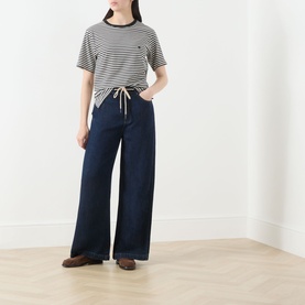 Model wearing Max Mara Weekend Venaco Logo Striped T-Shirt in black, styled with wide-leg dark denim jeans and brown loafers.