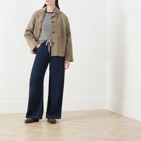 Model wearing Max Mara Weekend Venaco Logo Striped T-Shirt in black, styled with beige jacket, wide-leg navy trousers and brown loafers.