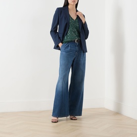 Model wearing Max Mara Weekend Milord Embellished Knitted Vest in green, styled with navy blazer, wide-leg denim jeans and brown heeled sandals.