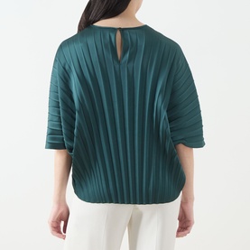 Model wearing Max Mara Weekend Aureo Pliss&eacute; Top in dark green, showing back view with button-loop fastening, kimono sleeves, and pleated texture.