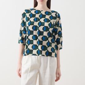 Model wearing Max Mara Weekend Adone Printed Blouse in dark green geometric print, three-quarter sleeves, styled with white wide-leg trousers