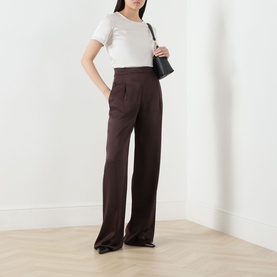 Model wearing Max Mara Weekend Gilbert Solid Blouse in Ivory with brown wide-leg trousers, carrying a black shoulder bag.