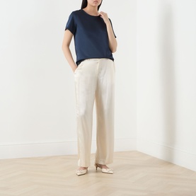 Model wearing Max Mara Weekend Gilbert Solid Blouse in navy, short sleeves, satin finish, styled with cream wide-leg trousers and nude ballet flats