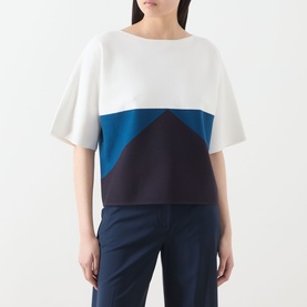 Model wearing Max Mara Main navy colour-block top with white, teal and dark navy geometric panels, styled with navy trousers.