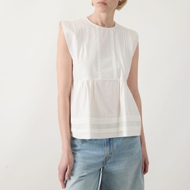 Model wearing Max Mara Weekend Vallo Peplum Blouse in white with gathered waist, pleated hem detail, styled with light blue jeans.