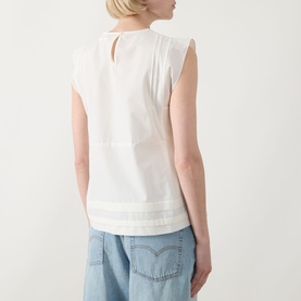 Model wearing Max Mara Weekend Vallo Peplum Blouse in white, back view showing keyhole fastening, styled with light blue wide-leg jeans.