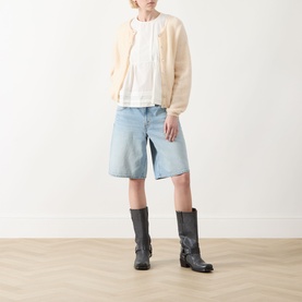 Model wearing Max Mara Weekend Vallo Peplum Blouse in white, styled with cream cardigan, light blue denim shorts and black knee-high boots