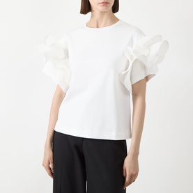 Model wearing Max Mara Main Costone Ruffle T-Shirt in white with voluminous taffeta ruffle sleeves, styled with black trousers