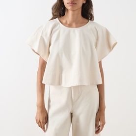 Model wearing Max Mara Weekend ecru cotton top with wide flutter sleeves and cropped silhouette, styled with matching ecru trousers.