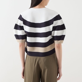 Model wearing Max Mara Main Voto Striped Sweater in ultramarine, back view, cropped knit with bold stripes, kimono sleeves, paired with khaki trousers