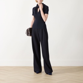 Model wearing Max Mara Main Palmeti Scarf Top in Ultramarine with wide-leg black trousers, styled with a small dark brown bag.