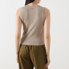 Model wearing Max Mara Main Ginseng Knitted Vest in stone, sleeveless with crew neckline, styled with olive wide-leg trousers. Back view.
